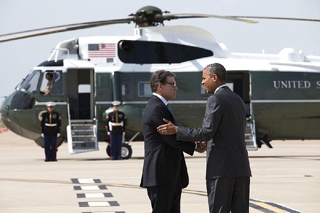 Texas Gov. Rick Perry greets President Barack Obama as he arrives Wednesday at Dallas-Fort Worth International Airport for a meeting with Texas officials on the immigration crisis.