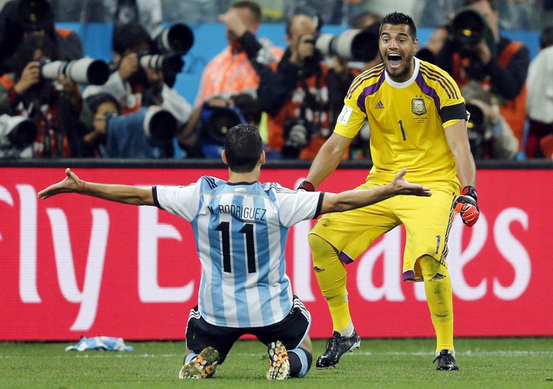 Argentina's Maxi Rodriguez, left, celebrates with goalkeeper Sergio Romero after scoring the decisive goal during the World Cup semifinal soccer match between the Netherlands and Argentina at the Itaquerao Stadium in Sao Paulo, Brazil, Wednesday, July 9, 2014. Argentina beat the Netherlands 4-2 in a penalty shootout to reach the World Cup final.