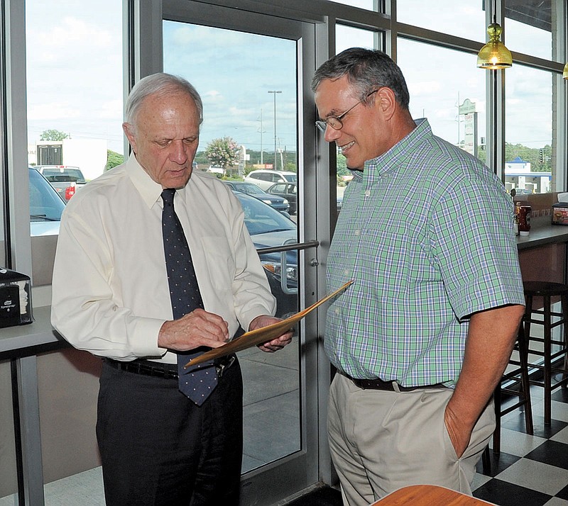 (The Sentinel-Record/Mara Kuhn CAMPAIGN STOP: Former U.S. Sen. David Pryor, left, and James Montgomery, of Hot Springs, look over old photographs during a campaign stop Wednesday at MOOYAH Burgers, Fries, and Shakes.