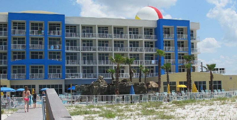 Tourists return from the beach at the Fort Walton Beach (Fla.) Holiday Inn Resort. The hotel is built on what the U.S. military knows as Eglin Air Force Range Test Site A5. The military constructed a radar intake site under a huge dome on the roof of the hotel that is painted like a beach ball, seen at upper right.