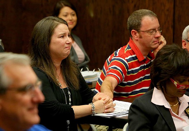 Candyce Allen grips the hand of her husband, Greg, as the state Board of Education overturns the Heber Springs School District’s denial of their school choice application during a Thursday meeting in Little Rock.