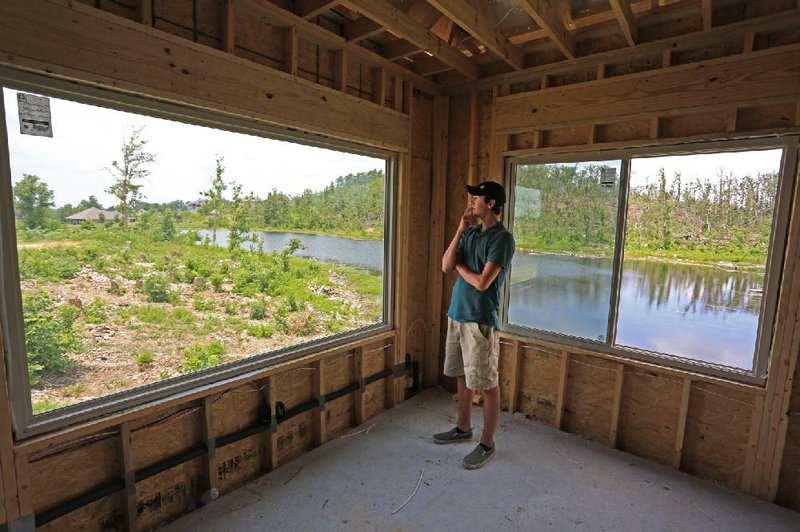 Chandler Belew, 19, looks out a window on Thursday in the family room being rebuilt in the home he shares with his parents, Donnie and Stacy Belew, near Mayflower. The April 27 tornado that struck Pulaski, Faulkner and White counties tore the Belew home apart, along with many others.