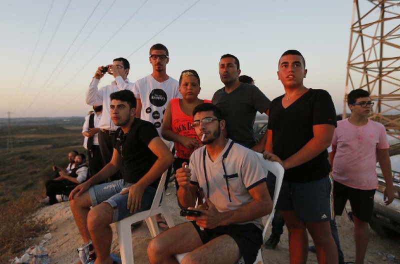 Israelis in the town of Sderot gather Thursday on a hill overlooking the Gaza Strip to watch for Israeli bombardments on Palestinian militants and missile intercepts of rockets fired by Palestinians.