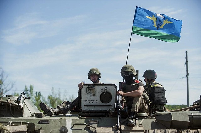 Ukrainian paratroopers ride Thursday atop an armored vehicle in Slovyansk, eastern Ukraine. In the past two weeks, Ukrainian government troops have halved the amount of territory held by the rebels. Now they are vowing a blockade of Donetsk.