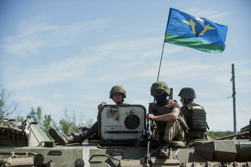 Ukrainian paratroopers ride Thursday atop an armored vehicle in Slovyansk, eastern Ukraine. In the past two weeks, Ukrainian government troops have halved the amount of territory held by the rebels. Now they are vowing a blockade of Donetsk.