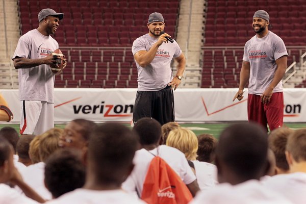 Former Arkansas Razorback football players who currently play in the NFL, Darren McFadden, Peyton Hillis and DJ Williams talk to participants in the youth NFL Legends at Verizon Arena in North Little Rock on Friday.