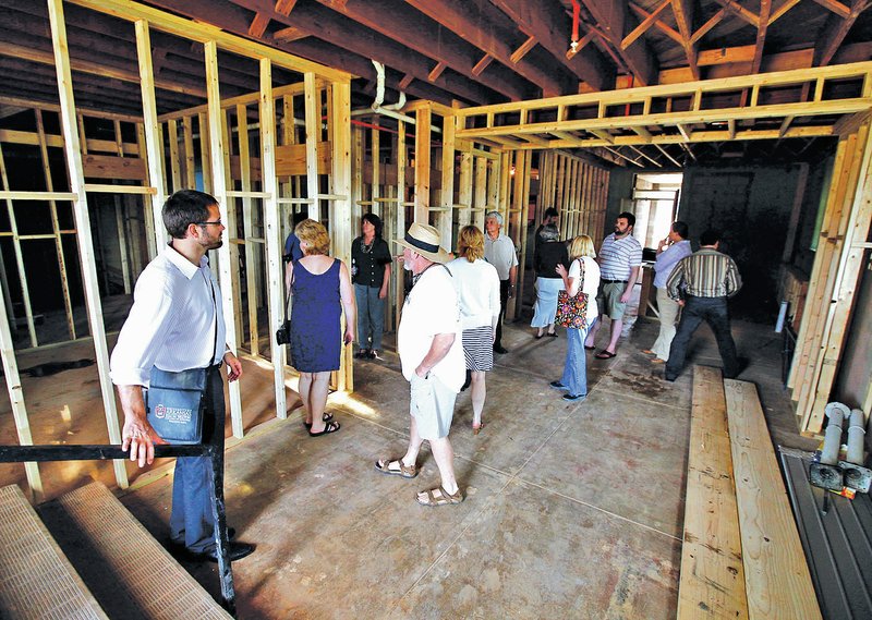 STAFF PHOTO JASON IVESTER Visitors tour City Hall Lofts under construction in downtown Rogers in a July file photo.