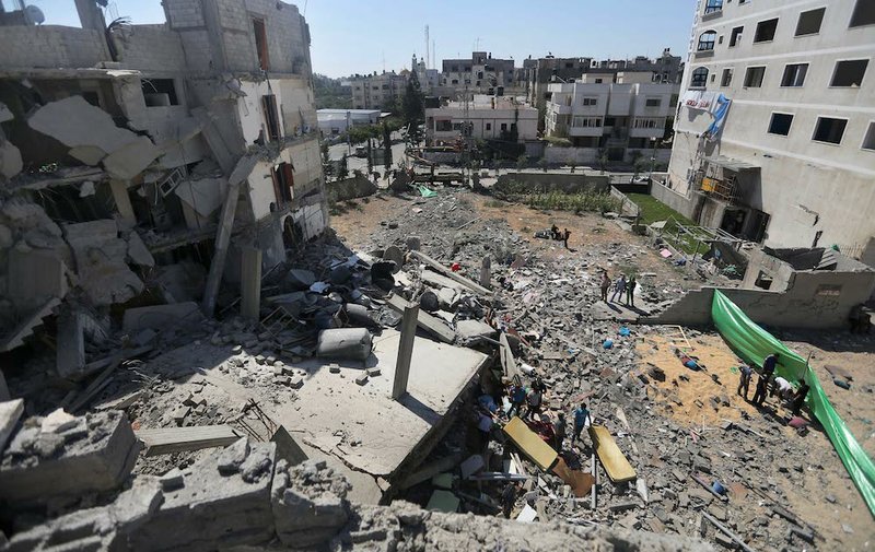 Palestinians inspect the rubble of a building after it was hit by an Israeli missile strike in Gaza City on Friday, July 11, 2014. Israel launched the Gaza offensive to stop incessant rocket fire that erupted after three Israeli teenagers were kidnapped and killed in the West Bank and a Palestinian teenager was abducted and burned to death in an apparent reprisal attack. The military says it has hit more than 1,100 targets already, mostly what it identified as rocket-launching sites, bombarding the territory on average every five minutes.