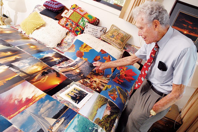 Carl Garner, resident engineer at Greers Ferry Lake, was a community leader who was involved in the preservation of Greers Ferry Lake for more than 50 years. In this 2009 photo, he shows some of the nature photos he has taken. Garner died July 6 at the age of 99.