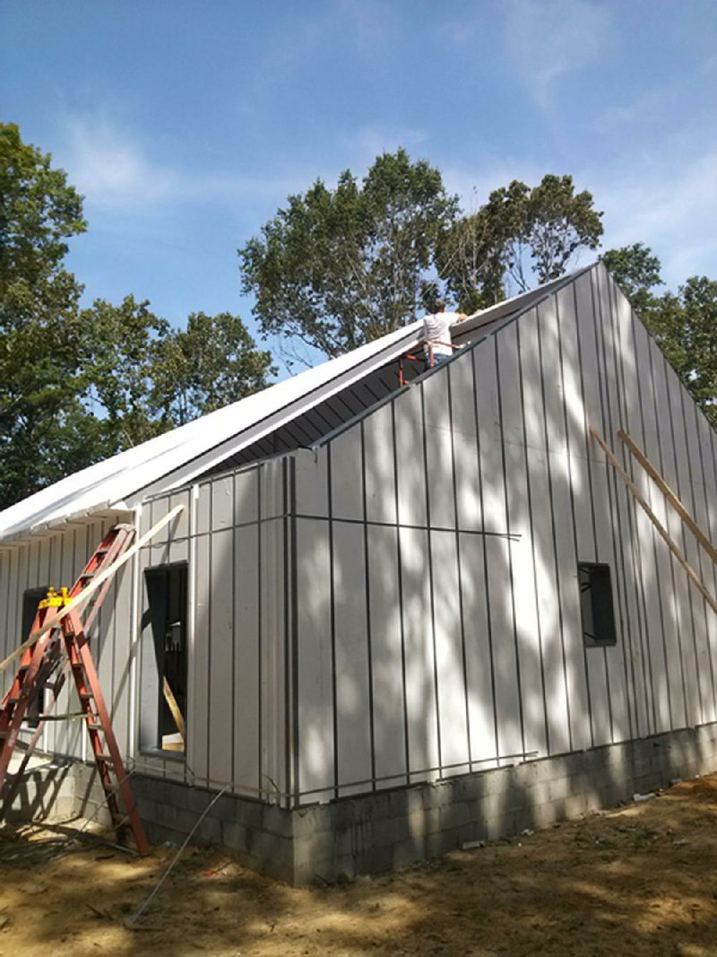 Special to the Arkansas Democrat Gazette - 07/10/2014 - A contractor installs foam roof panels on a green home. The roof and walls took about three days to install.