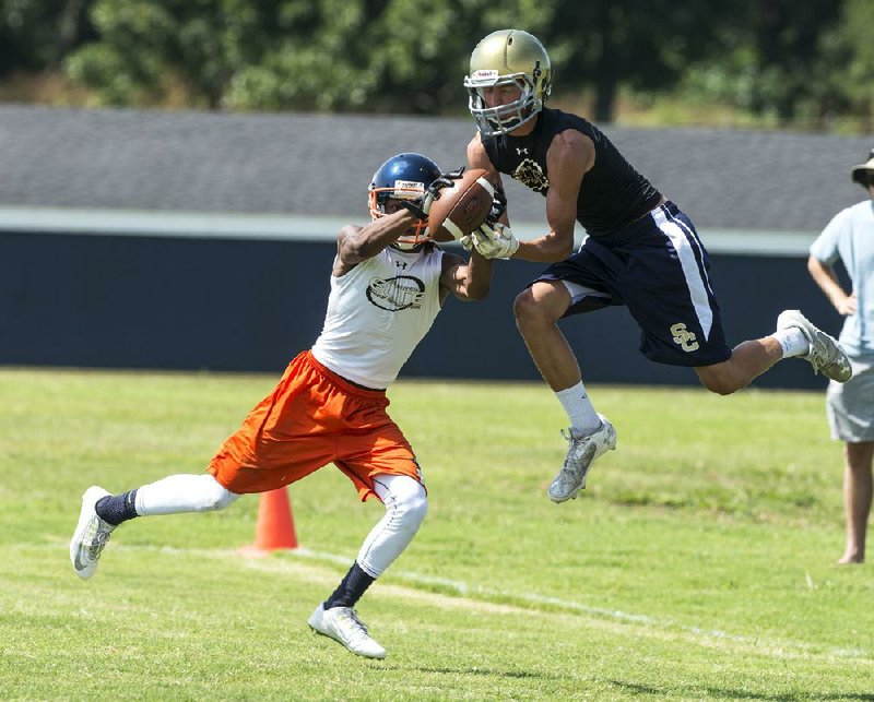 Jerral Hobbs (left) of Rogers Heritage intercepts a pass intended for Shiloh Christian’s Reed Lowe on Friday during the Southwest Elite 7-on-7 Showcase in Springdale.
