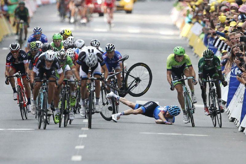 Andrew Talansky of the United States crashes as the pack, with stage winner Matteo Trentin (left foreground), sprints toward the finish line Friday in the 145.7-mile seventh stage of the Tour de France in Nancy, France.