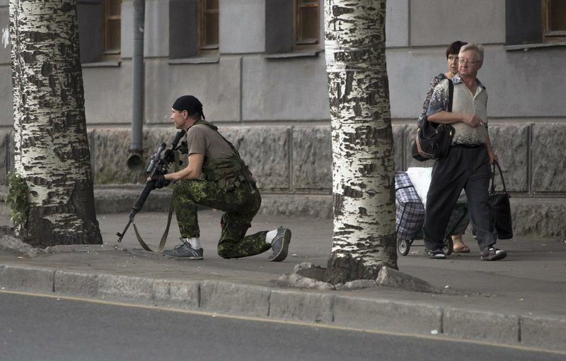 A militiaman stands guard near a shopping mall that was damaged by an explosion Friday in the city of Donetsk in eastern Ukraine.