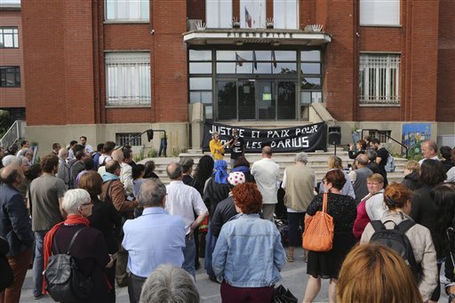 In this Friday, June 27, 2014 file photo, people gather at the Pierrefitte Town Hall, north of Paris, in a show of solidarity with a Roma teenager who was left bleeding and unconscious in a grocery cart by the side of a highway. It looked like any shantytown the world over — tarps to keep out the weather, scattered bits of trash that no truck would ever collect, plastic buckets to lug water. Then one of the inhabitants of this Roma camp on the northwest edge of Paris, a teenage boy named Darius, was beaten into a coma, apparently by residents of a neighboring housing project. Within hours, the Roma vanished, seeking sanctuary in a new location on the fringes of one of the world's wealthiest cities. Three weeks later, 16-year-old Darius remains unconscious. His family is in hiding. Police have made no arrests. France is coming under increasing pressure to answer allegations that it is encouraging harassment of Europe's poorest minority group in hopes that the Roma, also known as Gypsies, will leave the country. 