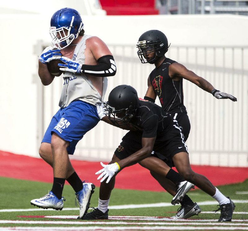 Arkansas Democrat-Gazette/Melissa Sue Gerrits - 07/12/2014 - Sylvan Hills' Elijah Sowards make a touchdown while shaking Jonesboro defenders during their 7 on 7 Championship game against Jonesboro July 12, 2014 at War Memorial Stadium 