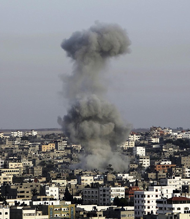 A plume of smoke rises from an Israeli airstrike in a densely populated area of Gaza City on Saturday. Officials promised to “raise the bar” until Hamas is deterred from continuing its rocket attacks.