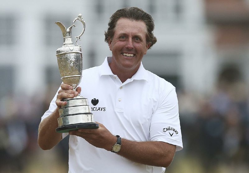 Phil Mickelson of the United States holds up the Claret Jug trophy after winning the British Open Golf Championship at Muirfield, Scotland, Sunday July 21, 2013.  (AP Photo/Scott Heppell)