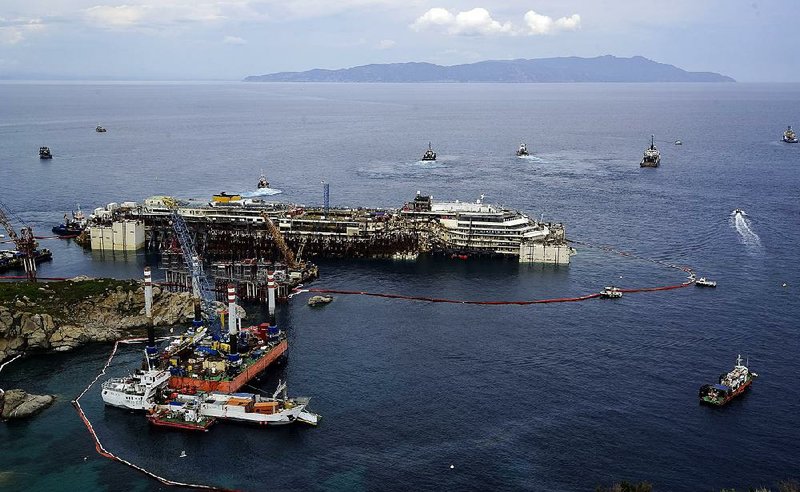 Operations to refloat and tow away the luxury cruise ship Costa Concordia get underway on the tiny Tuscan island of Giglio, Italy, Monday, July 14, 2014. The shipwrecked Costa Concordia was successfully refloated in preparation to be towed away for scrapping, 30 months after it struck a reef and capsized, killing 32 people. The entire operation to remove the Concordia from the reef and float it to the Italian port of Genoa, where it will be scrapped, will cost a total of 1.5 billion euros (2 billion US dollars), Costa Crociere SpA CEO Michael Tamm told reporters. (AP Photo/Alessandro La Rocca, LaPresse) ITALY OUT