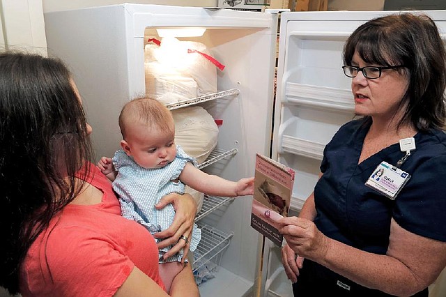 Jessica Donahue (right) oversees the milk depot at the Baptist Health Expressly For You Store, where mothers like Darby Beranek and baby Lucinda drop off their excess breast milk to be shipped to Mothers’ Milk Bank of North Texas for pasteurization.