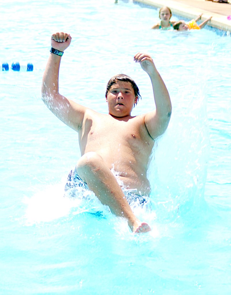 Photo by Randy Moll Kurtis Hubbard, 14, hits the water and makes a big splash after going off the diving board at Gravette&#8217;s municipal pool on July 2.