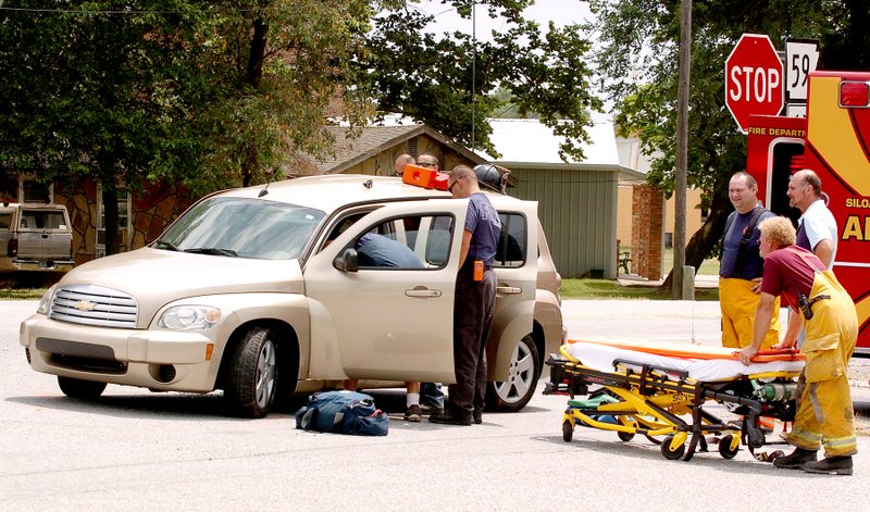 Photo by Randy Moll Gentry Fire Department EMTs work to remove a driver from a car involved in an accident at the intersection of Main Street and Gentry Blvd. on July 8. Drivers in the accident were Sharon Stewart and Kinzie Shook. An accident report was not yet available at press time, but police said Stewart was eastbound on Main Street and failed to yield at the stop sign and was struck by a southbound vehicle driven by Shook.