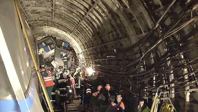 In this frame grab  from a video provided by the Russian Ministry for Emergency Situations showing rescue teams working inside the tunnel where several cars of the wrecked train look almost coiled, occupying the entire space of the tunnel of Moscow subway in Moscow, Russia, on Tuesday, July 15, 2014. Workers were seen trying to force open the mangled doors of the car where dead bodies are supposed to be. A rush-hour subway train derailed in Moscow Tuesday, killing about a dozen people and injuring