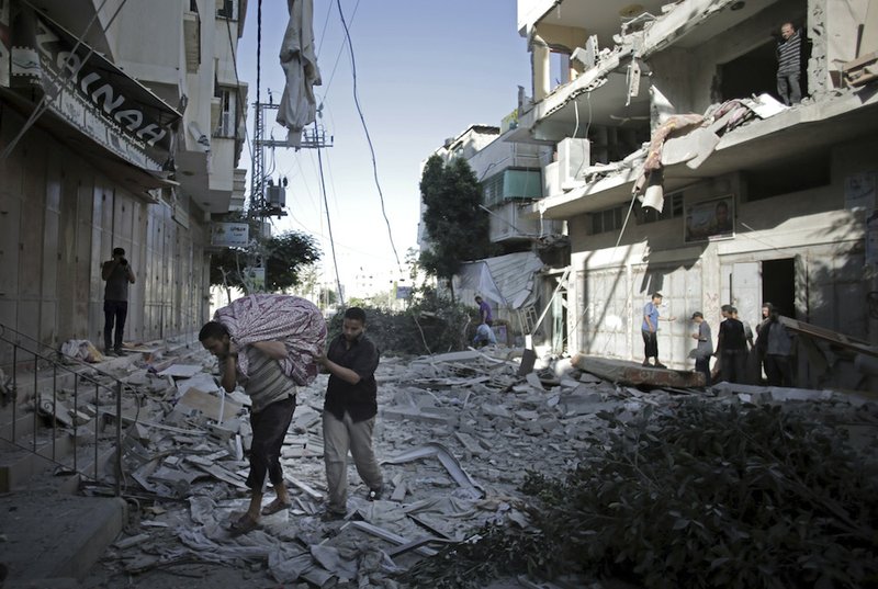 Palestinians salvage what they can of their belongings from the rubble of their destroyed house after an early morning Israeli missile strike in Gaza City on Wednesday, July 16, 2014. A Hamas website says Israel has fired missiles at the homes of four of its senior leaders as it resumed bombardment of Gaza, after a failed Egyptian cease-fire effort. 