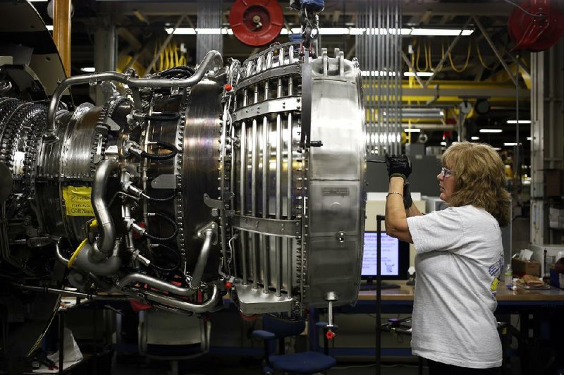 A mechanic installs a safety cable on a jet engine last month at a General Electric factory in Cincinnati. Factory production rose 0.1 percent in June, the Federal Reserve said.