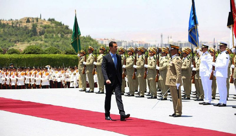 Syrian President Bashar Assad reviews an honor guard Wednesday upon his arrival at the presidential palace in Damascus to take the oath of office for his third term.