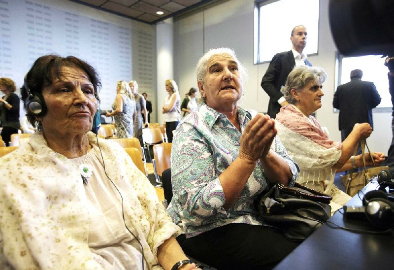 Women from Srebrenica wait for judges to enter civil court Wednesday in The Hague, Netherlands.