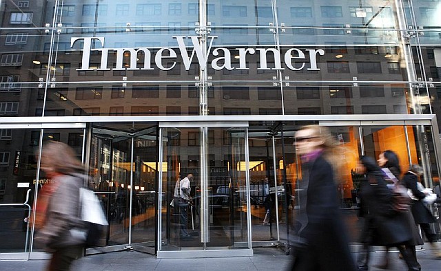 People walk past the Time Warner Center in New York. The company on Wednesday rejected an offer valued at $80 billion to merge with 21st Century Fox, but further negotiations are likely, analysts said.