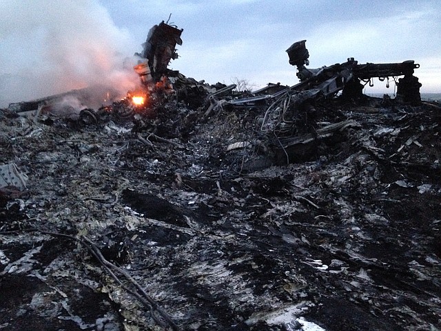 Smoke rises up at a crash site of a passenger plane, near the village of Hrabove, Ukraine, Thursday, July 17, 2014. A Ukrainian official said a passenger plane carrying 295 people was shot down Thursday as it flew over the country and plumes of black smoke rose up near a rebel-held village in eastern Ukraine. Malaysia Airlines tweeted that it lost contact with one of its flights as it was traveling from Amsterdam to Kuala Lumpur over Ukrainian airspace.