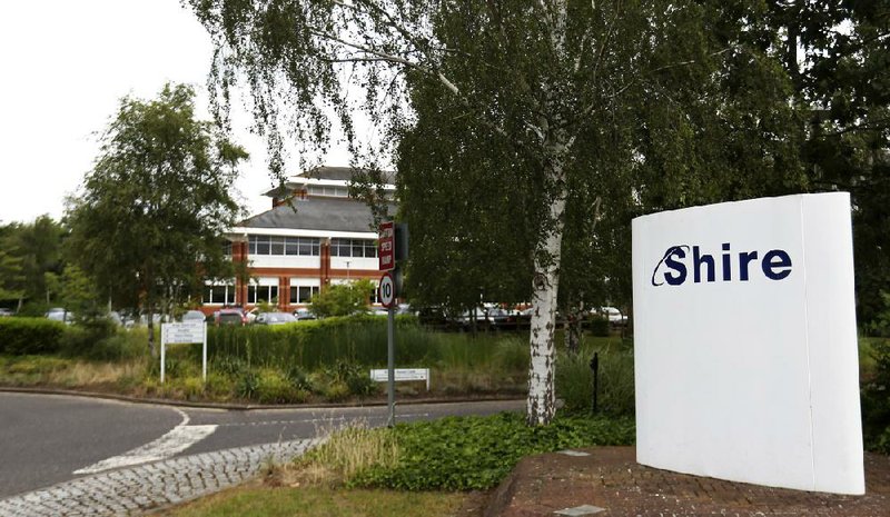 A Shire logo sits on a sign outside office buildings at Shire Plc's site in Chineham, U.K., on Friday, June 27, 2014. AbbVie Inc. said its $46.5 billion bid for Shire offers "compelling" value for Shire shareholders and that it won't rule out going hostile in its drive to acquire the drugmaker. Photographer: Chris Ratcliffe/Bloomberg