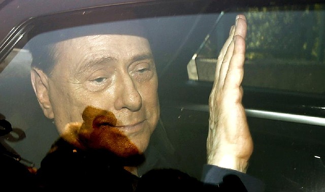 Italy’s former Premier Silvio Berlusconi waves as he leaves the Sacra Famiglia institute in Cesano Boscone, Italy, on Friday.