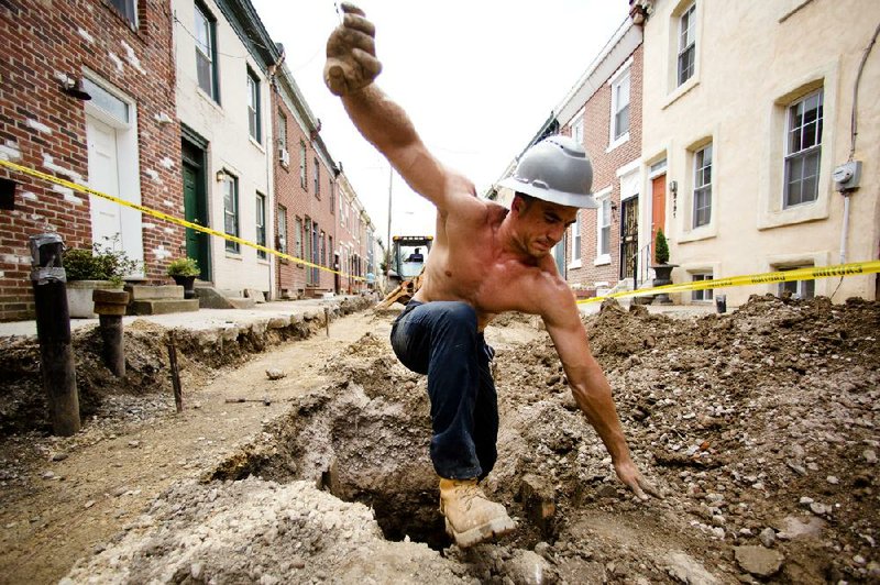 In this July 3, 2014 photo, construction worker Vinny Chase climbs out of a pit during a sewer and water line project in Philadelphia. The Conference Board reports on its index of leading economic indicators for June on Friday, July 18, 2014. (AP Photo/Matt Rourke)
