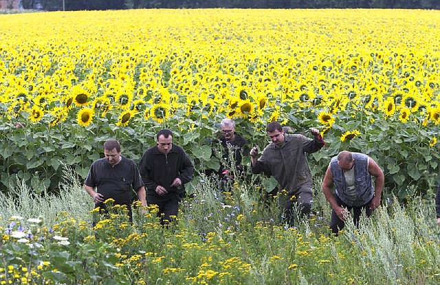 Ukrainian coal miners help search the area Friday near the village of Rozsypne in eastern Ukraine where a Malaysia Airlines jetliner went down Thursday.