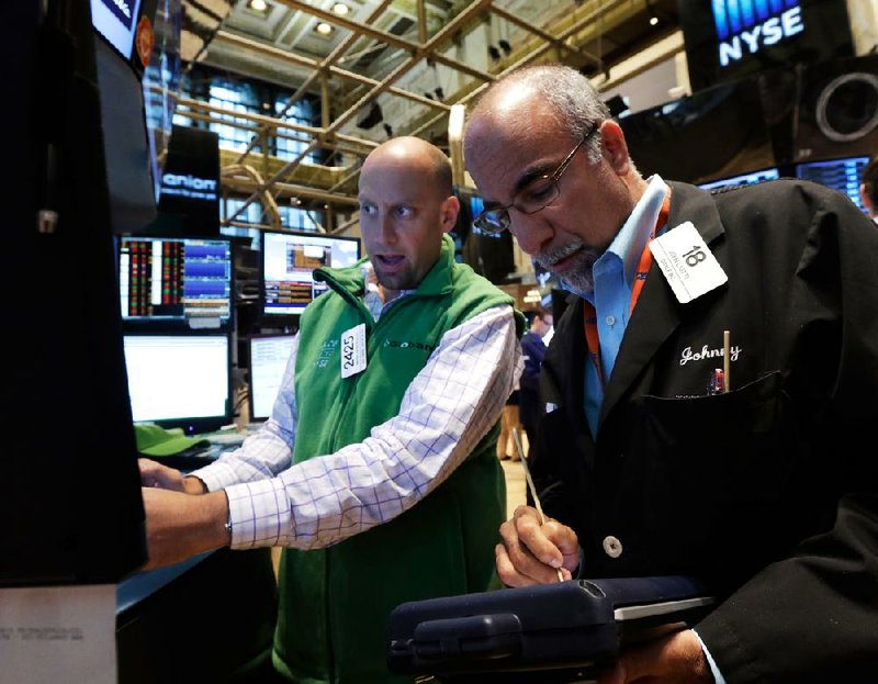 Specialist Meric Greenbaum, left, and trader John Liotti work on the floor of the New York Stock Exchange Friday, July 18, 2014. U.S. stocks are opening higher after Google, Honeywell and other big companies report their quarterly results. (AP Photo/Richard Drew)