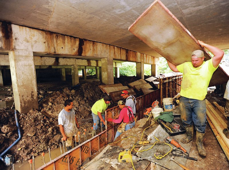 STAFF PHOTO ANDY SHUPE Workers with Arco Excavation and Paving in Bentonville assemble forms Friday before pouring concrete pathways and barriers in Town Branch beneath South School Avenue in Fayetteville. The work is a part of an extension of the city&#8217;s trail system linking to Mount Kessler and a planned regional park.