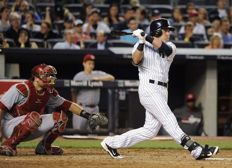 New York Yankees' Jacoby Ellsbury follows through on a two-run home run off of Cincinnati Reds starting pitcher Mike Leake as Devin Mesoraco catches for the Reds in the fifth inning of an interleague baseball game at Yankee Stadium on Friday, July 18, 2014, in New York. 