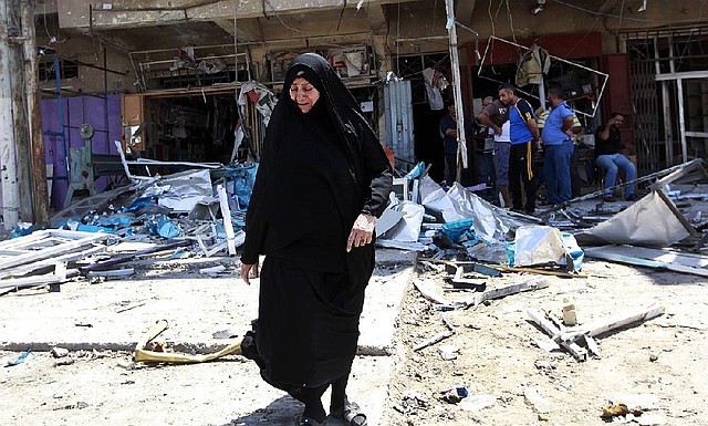 Civilians inspect the site of a bomb attack in the Jihad neighborhood in Baghdad, Saturday, July 19, 2014. A series of bombings, including three over a span of less than 10 minutes, killed and wounded dozens of people across Baghdad on Saturday, shaking the fragile sense of security the capital has maintained despite the Sunni militant offensive raging across northern and western Iraq. (AP Photo/Hadi Mizban)