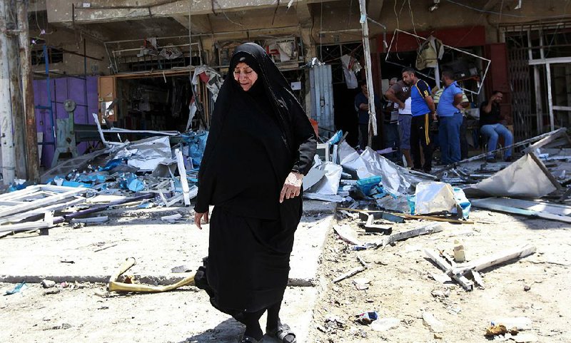 Civilians inspect the site of a bomb attack in the Jihad neighborhood in Baghdad, Saturday, July 19, 2014. A series of bombings, including three over a span of less than 10 minutes, killed and wounded dozens of people across Baghdad on Saturday, shaking the fragile sense of security the capital has maintained despite the Sunni militant offensive raging across northern and western Iraq. (AP Photo/Hadi Mizban)