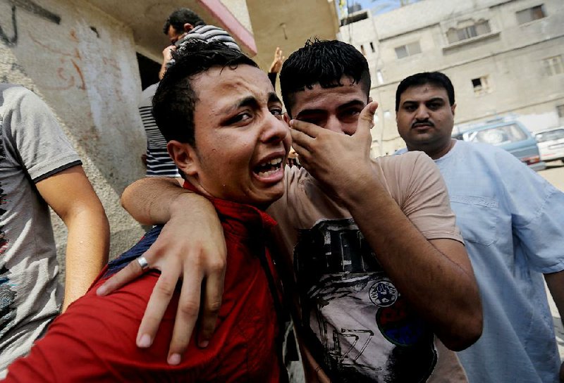 Palestinian relatives mourn for Qasim Alwan, 4, and Imad Alwan, 6, who were killed Friday by an Israeli tank shell, during their funeral in Gaza City, Saturday, July 19, 2014. Relatives say the tank shell kit the Alwan family's kitchen, killing Qasim and Imad. Rizk Hayek, 1, who lived nearby, was killed by shrapnel. (AP Photo/Hatem Moussa)