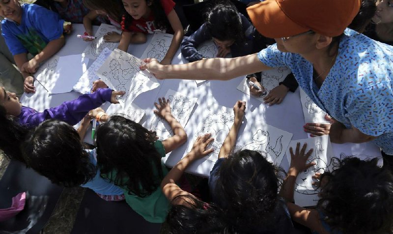 FILE - This June 18, 2014 file photo shows children detainees coloring and drawing at a U.S. Customs and Border Protection (CPB) processing facility in Brownsville,Texas. From October 2012 through September 2013, the U.S. Border Patrol apprehended about 24,000 unaccompanied children. But the number shot up to 57,000 from October 2013 through June 2014. Secretary of Homeland Security Jeh Johnson testified recently that the number is accelerating so fast that it could reach 90,000 by the end of September. Most of the children are coming from El Salvador, Honduras and Guatemala. (AP Photo/Eric Gay, Pool)