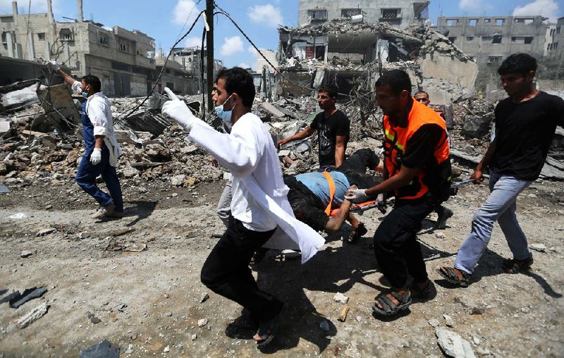 Palestinian medics carry a man injured in Gaza City's Shijaiyah neighborhood that came under fire as Israel widened its ground offensive against Hamas in the northern Gaza Strip on Sunday, July 20, 2014. Tens of people were killed in Shijaiyah and many more bodies were believed buried under the rubble of homes, health officials said. They are the latest casualties in a nearly two-week conflict that has killed some 380 Palestinians and seven Israelis. (AP Photo/Hatem Moussa)