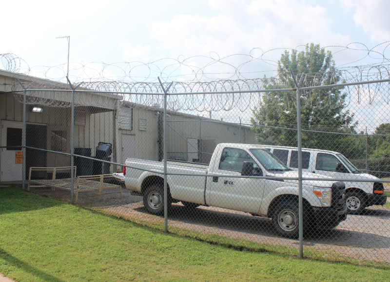 Arkansas Department of Correction vehicles sit outside the former Pulaski County sheriff's office work center Monday shortly after the state agreed to lease the facility to house some state inmates.