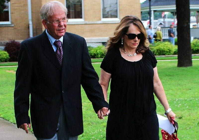 FILE — Former Saline County Sheriff Bruce Pennington leaves the Saline County Courthouse on June 9, 2014, with his wife, Barbara, after pleading innocent to felony charges of abuse of public trust and theft of property as well as a misdemeanor.