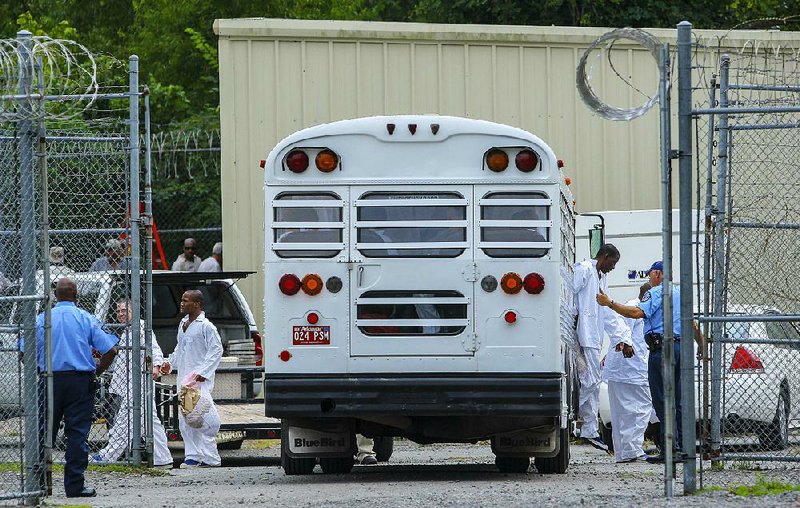 State inmates who had been housed at the Pulaski County jail in Little Rock arrive Monday at a nearby satellite building the state Department of Correction is leasing to relieve crowded conditions.