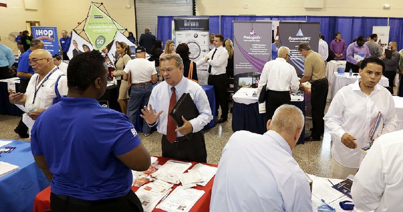 Job seekers check out the employment opportunities at a job fair for military veterans in Fort Lauderdale, Fla., on Wednesday. Fiftyseven percent of the respondents to a survey by the National Association for Business Economics reported sales increases in the second quarter.