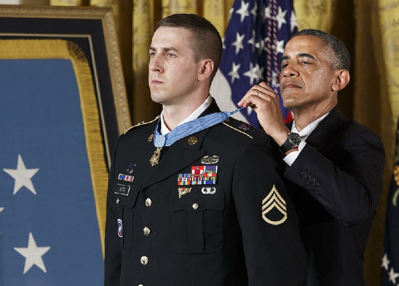 President Barack Obama presents the Medal of Honor to Ryan M. Pitts, 28, of Nashua, N.H., in the East Room of the White House in Washington on Monday.