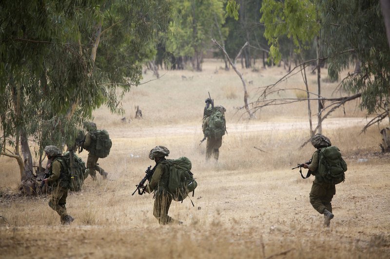 Israeli soldiers march during a drill near the Israel and Gaza border, Tuesday, July 22, 2014. Israeli airstrikes pummeled a wide range of targets in the Gaza Strip on Tuesday as the U.N. chief and the U.S. secretary of state began an intensive effort to end more than two weeks of fighting that has killed hundreds of Palestinians and dozens of Israelis. 